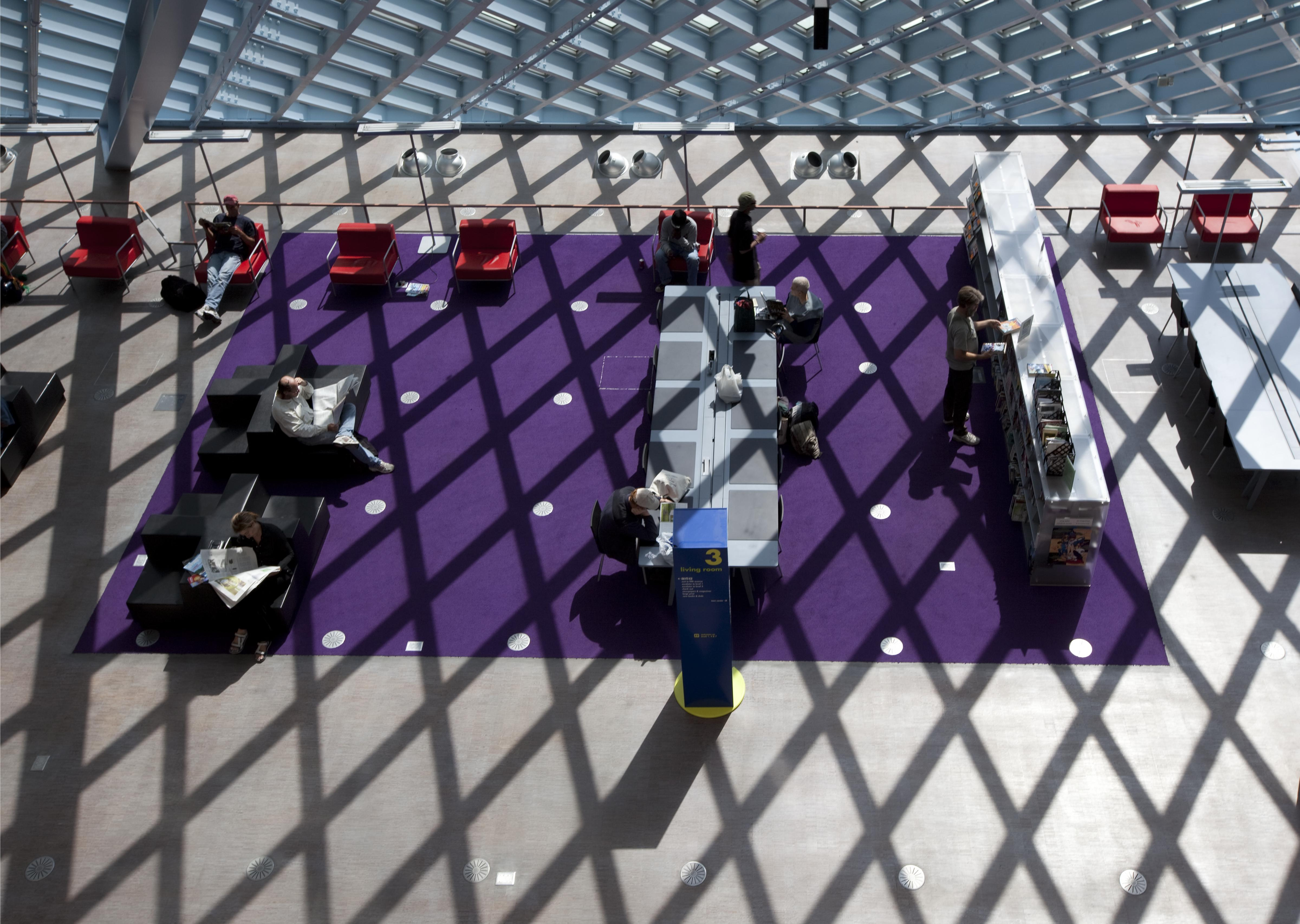 Visitors moving freely through the open reading floors of a public library